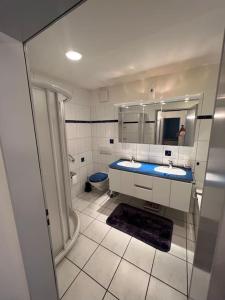 a bathroom with two sinks and a toilet and a mirror at Centered Apartment with view in Altdorf