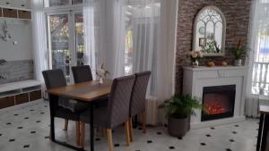a dining room with a table and a fireplace at Victoria Family Hotel in Balchik