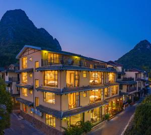 an apartment building with lights on at night at Guilin Village Creek Inn in Guilin