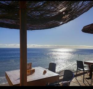 カンデラリアにあるTHE HAPPINESS PENTHOUSE Dream Holiday at 100m Beach!のテーブルと椅子から海の景色を望めます。