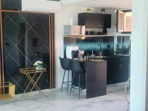 cocina con fregadero y encimera con taburetes en סוויטות נוף קיסר קיסריה en Caesarea