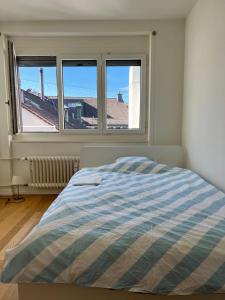ein Schlafzimmer mit einem Bett und drei Fenstern in der Unterkunft City Center Studio at town hall in Basel