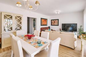 uma sala de estar com uma mesa branca e cadeiras em Casa da Praia mit Poolanlage em Porches