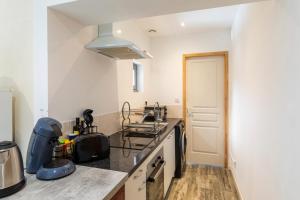 a kitchen with a sink and a stove at Tranquillité - Maison climatisée avec jardin in Golfech +4 photos