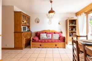 sala de estar con sofá rojo y almohadas en L'Etoile Blanche - Appt vue montagne, en Flumet