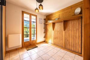 un pasillo con una gran puerta de madera y una ventana en L'Etoile Blanche - Appt vue montagne, en Flumet