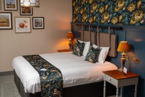 ein Hotelzimmer mit einem Bett und einem Gemälde an der Wand in der Unterkunft Ethorpe Hotel by Chef & Brewer Collection in Gerrards Cross