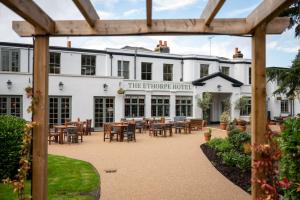 una vista exterior del hotel con chimenea, mesas y sillas en Ethorpe Hotel by Chef & Brewer Collection, en Gerrards Cross