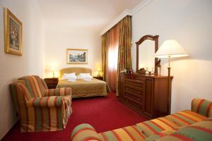 ein Hotelzimmer mit einem Bett und zwei Stühlen in der Unterkunft Hotel Globo in Split