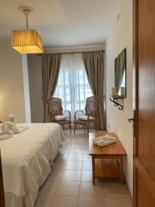 a bedroom with a bed and chairs and a window at Edificio Oriòn, Apartamento E11 in Tazacorte