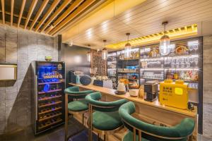 a bar with green stools in a restaurant at 北京悦明元星空白塔景观四合院民宿 in Beijing