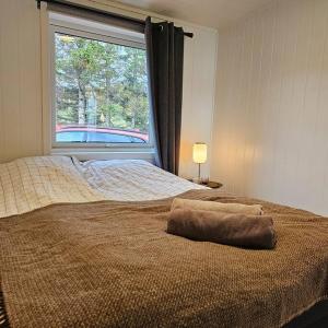 een slaapkamer met een bed en een groot raam bij Peaceful small house by the sea in Tromsø