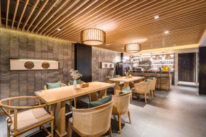 a restaurant with wooden tables and chairs and a bar at 北京悦明元星空白塔景观四合院民宿 in Beijing