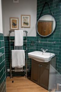 ein Bad mit einem Waschbecken und einem Spiegel in der Unterkunft Ethorpe Hotel by Chef & Brewer Collection in Gerrards Cross