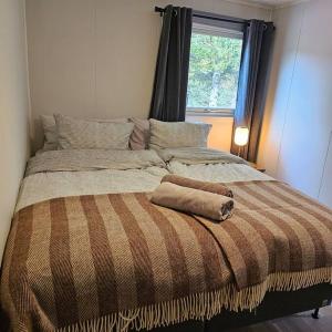 een groot bed in een kamer met een raam bij Peaceful small house by the sea in Tromsø