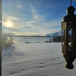 uma luz de rua com vista para um lago congelado em Peaceful small house by the sea em Tromsø