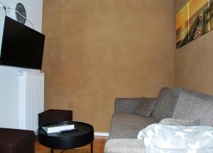 uma sala de estar com um sofá e uma mesa em Haus Santalla Whg. Unterdeck em Cuxhaven