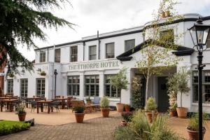 a hotel with tables and chairs in a courtyard at Ethorpe Hotel by Chef & Brewer Collection in Gerrards Cross