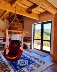 a room with a hammock in a room with a fireplace at Casa Bună Fundățica in Fundăţica