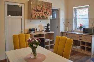 una cocina con una mesa con un jarrón de flores. en CONFORT HOUSE PLUS, en Alba Iulia