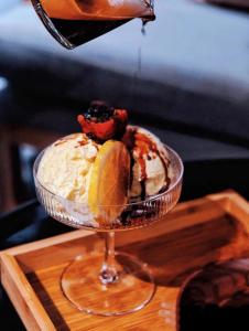 a dessert in a glass bowl on a wooden table at 北京悦明元星空白塔景观四合院民宿 in Beijing