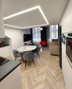 a kitchen and living room with a table and chairs at Central Gallery Apartment in Debrecen