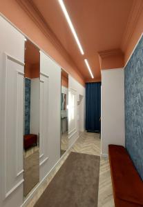 een hal met een kamer met witte muren bij Central Gallery Apartment in Debrecen