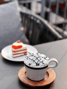 a cup of coffee and a piece of cake on a table at 北京悦明元星空白塔景观四合院民宿 in Beijing