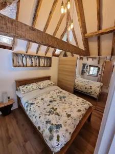 a bedroom with a bed in a room with wooden floors at Little Thatch in Corfe Castle