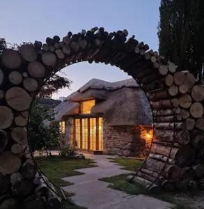 een stenen huis met een grote boog ervoor bij Little Thatch in Corfe Castle