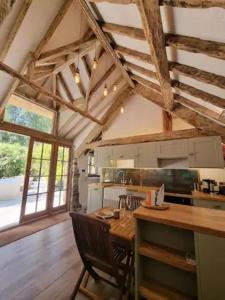 a kitchen with a table and chairs in a room at Little Thatch in Corfe Castle