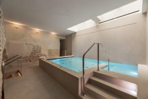 - Baño con bañera de hidromasaje y escalera en Áurea Toledo by Eurostars Hotel company, en Toledo