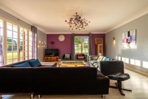 un salon avec des canapés et un lustre dans l'établissement Maison Carrosse - A 20min de Bordeaux, à Martillac