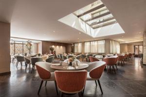 a restaurant with tables and chairs in a room at Áurea Toledo by Eurostars Hotel company in Toledo