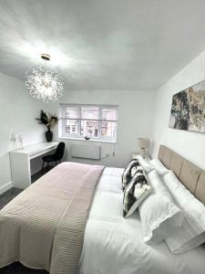 a white bedroom with a large bed and a window at Luxury 2-Bed Apartment Lindley Huddersfield in Huddersfield