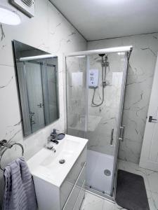 a white bathroom with a sink and a shower at Luxury 2-Bed Apartment Lindley Huddersfield in Huddersfield