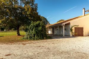 un edificio con un árbol delante en Maison Carrosse - A 20min de Bordeaux, en Martillac