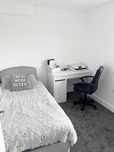 a bedroom with a bed and a desk and a chair at Luxury 2-Bed Apartment Lindley Huddersfield in Huddersfield