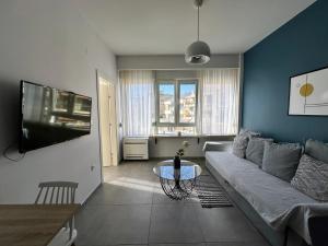 een woonkamer met een bank en een tafel bij Bella Suite city Center, Parking in Thessaloniki
