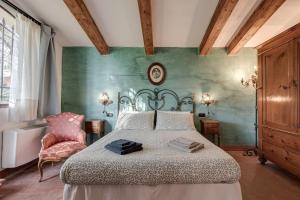 een slaapkamer met een bed en een stoel bij Il Pintello - Lo Scricciolo in Massanera