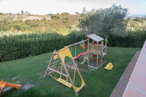een speeltuin met een glijbaan op het gras bij Il Pintello - Lo Scricciolo in Massanera
