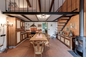 a kitchen with a wooden table and a dining room at Il Pintello - Lo Scricciolo in Massanera