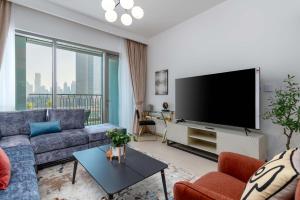 ein Wohnzimmer mit einem großen Flachbild-TV in der Unterkunft White Sage - Base to Top of Burj Khalifa Views in this New 2BR in Dubai