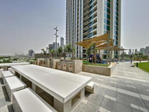 einen Park mit weißen Bänken und einem hohen Gebäude in der Unterkunft White Sage - Base to Top of Burj Khalifa Views in this New 2BR in Dubai