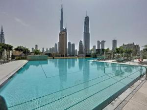 ein großer Pool mit einer Skyline der Stadt im Hintergrund in der Unterkunft White Sage - Base to Top of Burj Khalifa Views in this New 2BR in Dubai