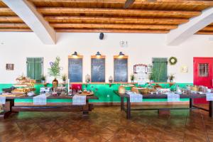 a large room with tables and chairs and a ceiling at Varos Village Boutique Hotel in Város