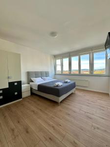 ein großes Schlafzimmer mit einem Bett und einigen Fenstern in der Unterkunft Mateo in Zadar