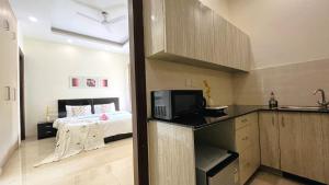 a small kitchen with a bed in a room at BluO Studio DLF CyberCity - Kitchen, Balcony, Lift in Gurgaon