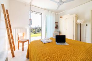 a bedroom with a bed with a laptop on it at Tenuta Quattro Volpi in Melendugno
