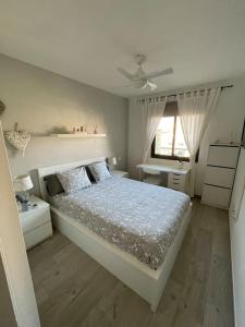 ein weißes Schlafzimmer mit einem Bett und einem Fenster in der Unterkunft Duplex con piscina cerca del mar in Puertito de Güímar
